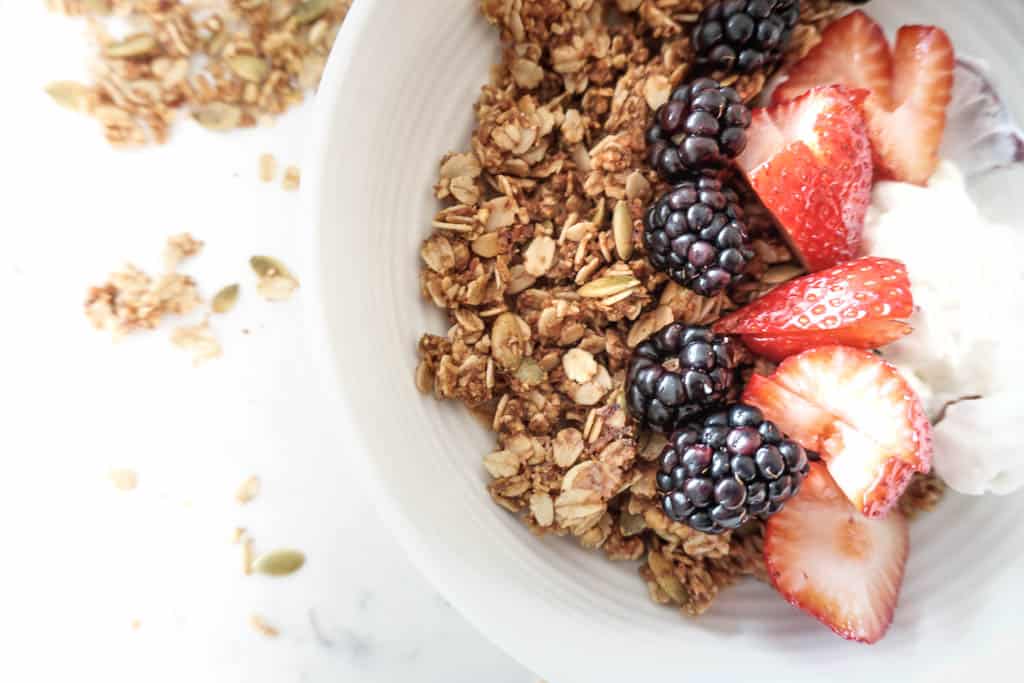 A granola breakfast bowl topped with blackberries, strawberries and yogurt