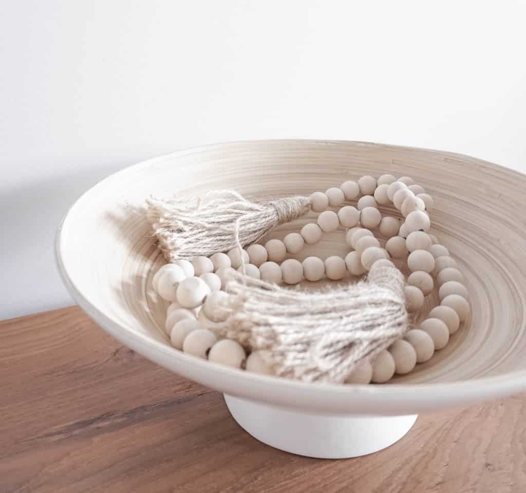 showing a toddler-friendly home decor idea with decorative beads in a patio bowl that looks like ceramic