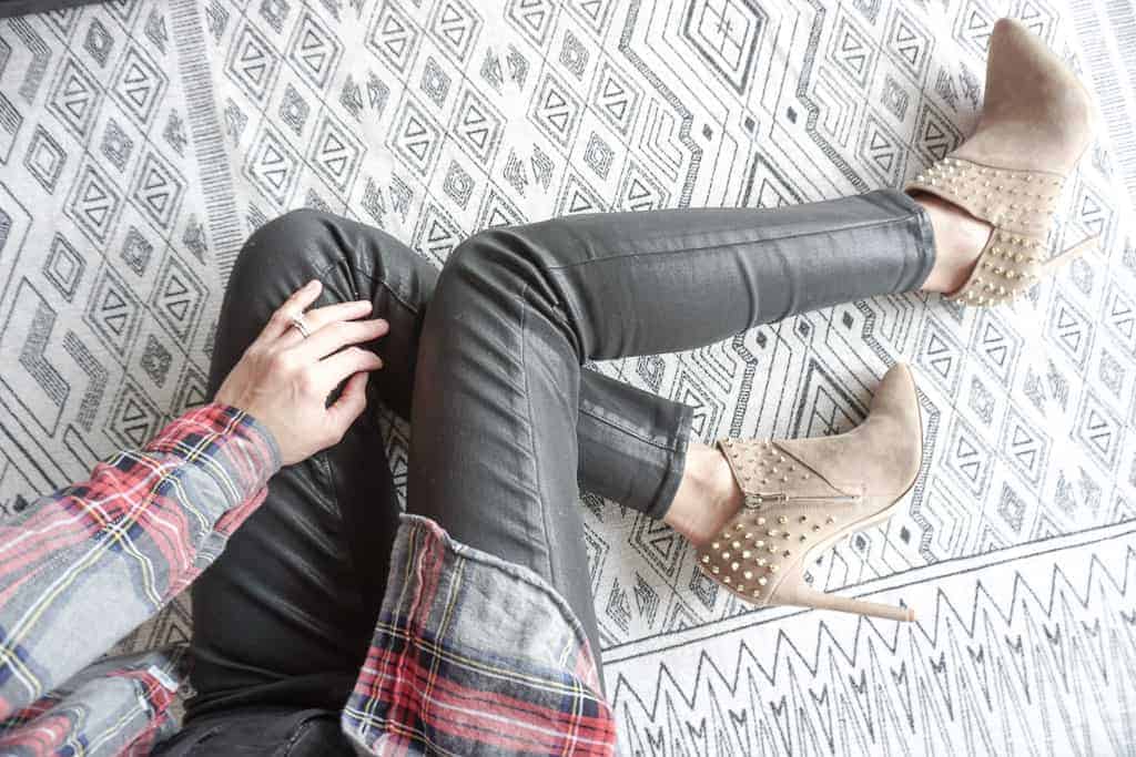 Signed Samantha's winter wardrobe staples include faux leather leggings, a good pair of boots, and a plaid shirt. All items she is wearing in this overhead shot of her legs, feet and a portion of her torso