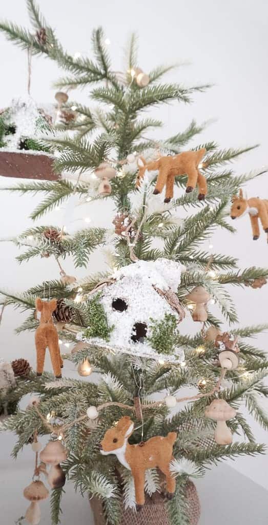 Signed Samantha's Holiday Mantle decor ideas includes choosing a theme - she picked woodland which includes deer ornaments, tree ornaments, mushroom garland, on a mini tree.