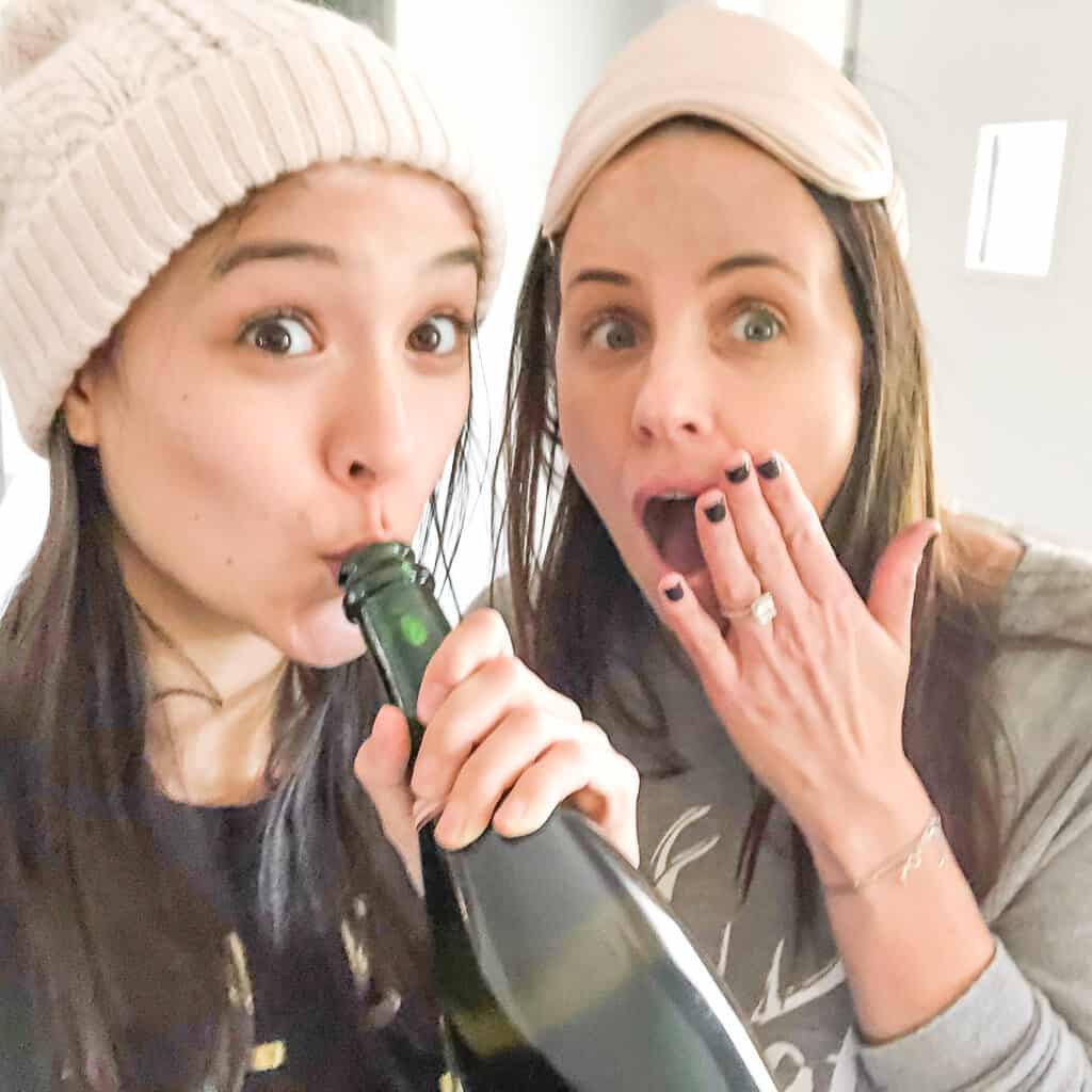 Holiday gift guides 2020 ideas for foodies, parents, and in-laws. Pictured in Signed Samantha with her mom, drinking out of a bottle of champagne - their christmas tradition.
