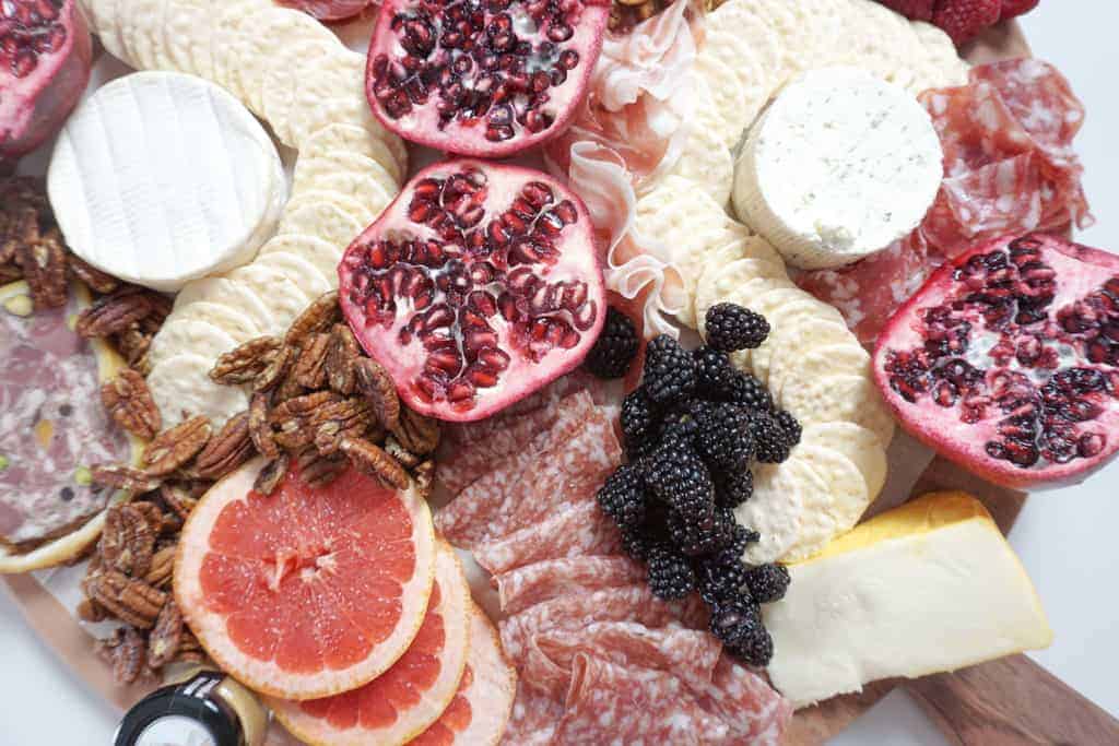 Signed Samantha's Christmas Grazing board ideas includes a traditional charcuterie board pictured with fresh fruit, crackers, cured meats and cheese.