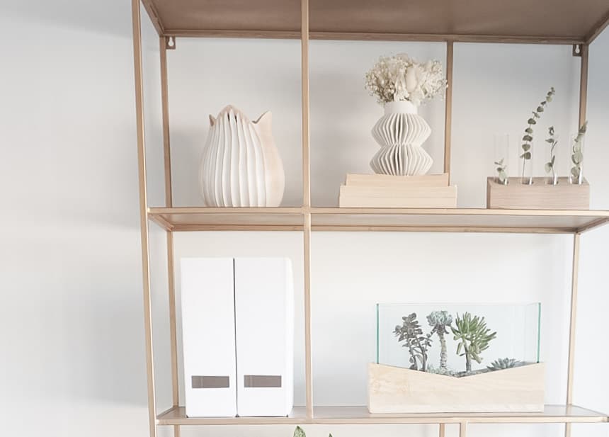 Sharing how to style shelves - showing the completed version on a gold shelf that has books, plants, vases, and file holders.