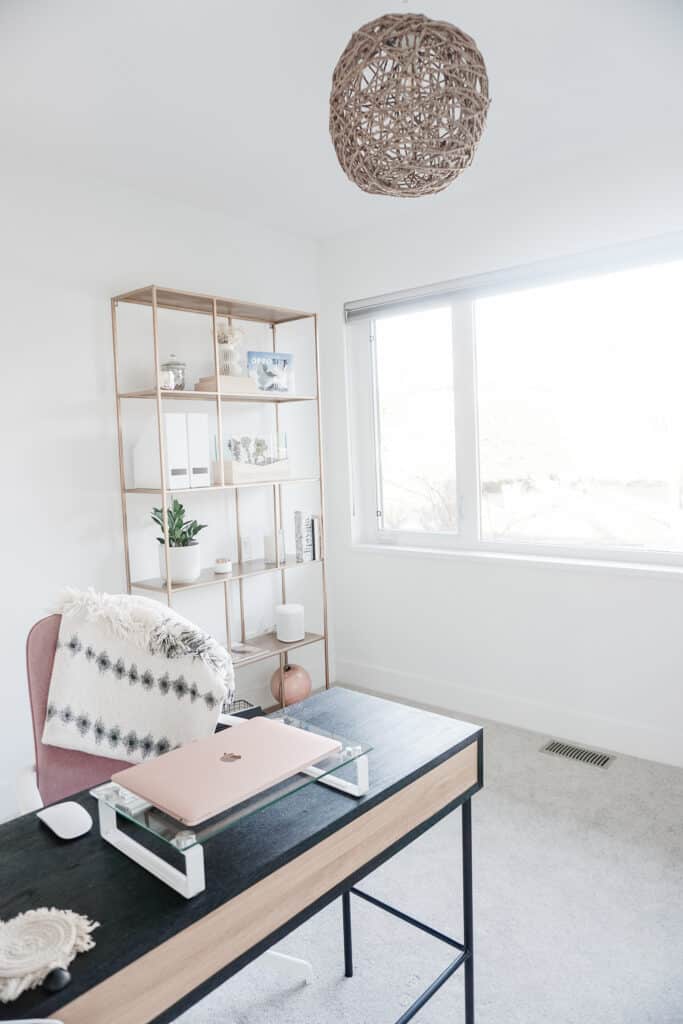 Signed Samantha's home office tour includes her DIY light, a gold book shelf decorated with neutral coloured items. a black oak desk and pink desk chair