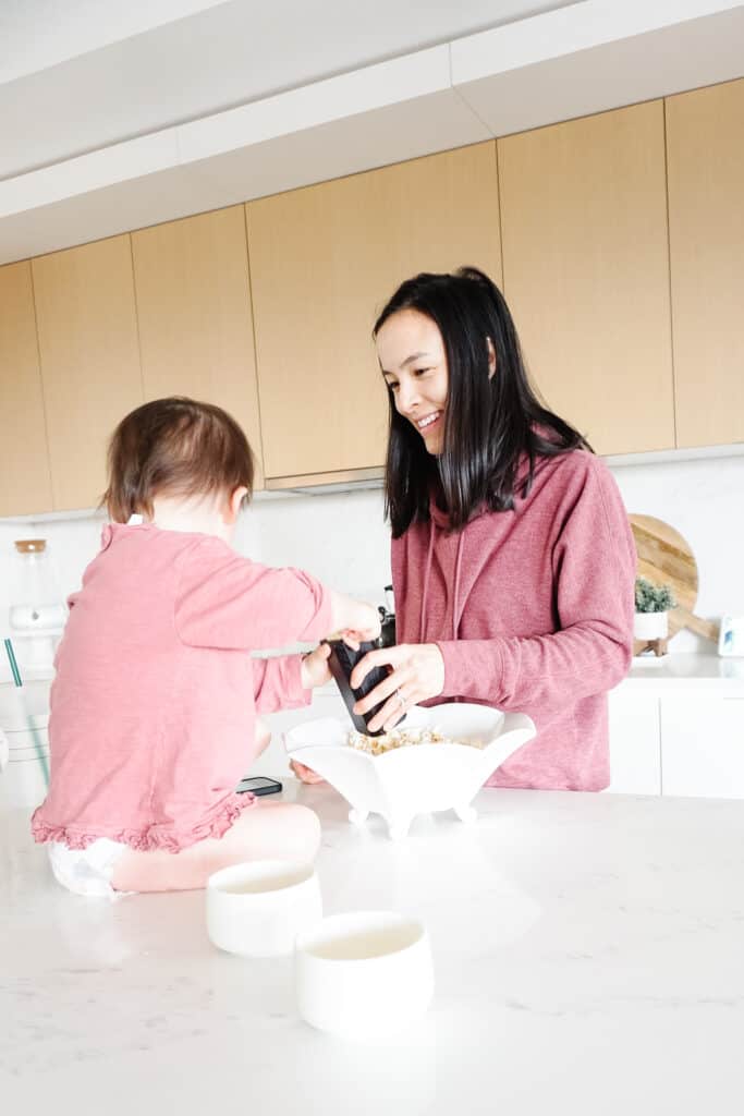 homemade popcorn topping ideas at Signed Samantha today. Samantha is making her favourite popcorn with Sloane in the kitchen. Sloane is cracking pepper onto the popcorn while sitting on the counter.