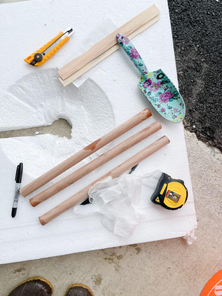 What you need to make your own concrete side table dowels, a shovel (or trowel if you have one), tape measure, exacto knofe, gloves, and a marker. All pictured here on top of sytrofoam - which was also used.