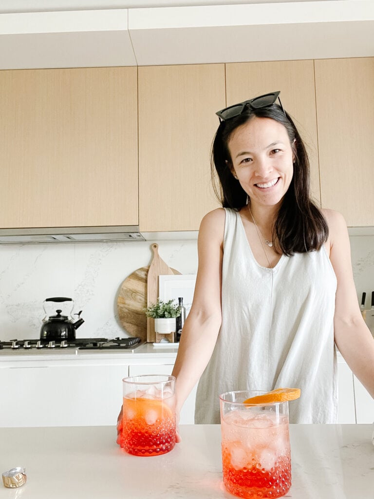 Signed Samantha standing in her kitchen in front of her aperol spritz