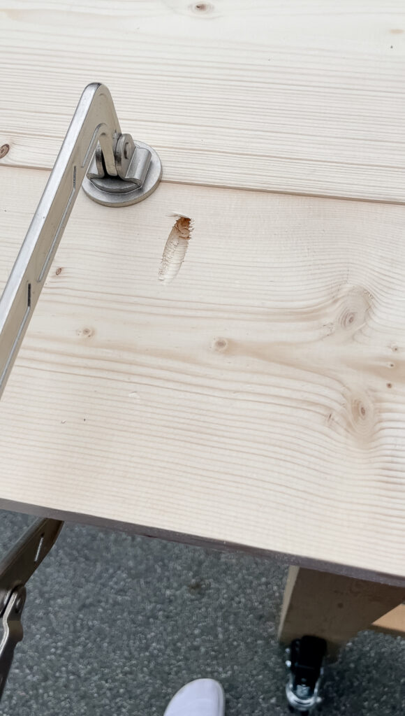 How to make your DIY rustic desk top with pocket screws - two 1x8s pictured with pocket hole and a screw on top and a clamp holding it together