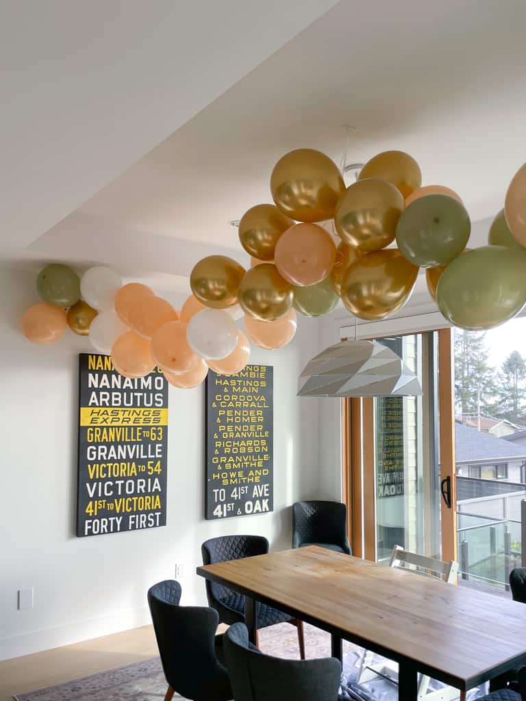 A dining room with a DIY balloon garland hanging above the table.