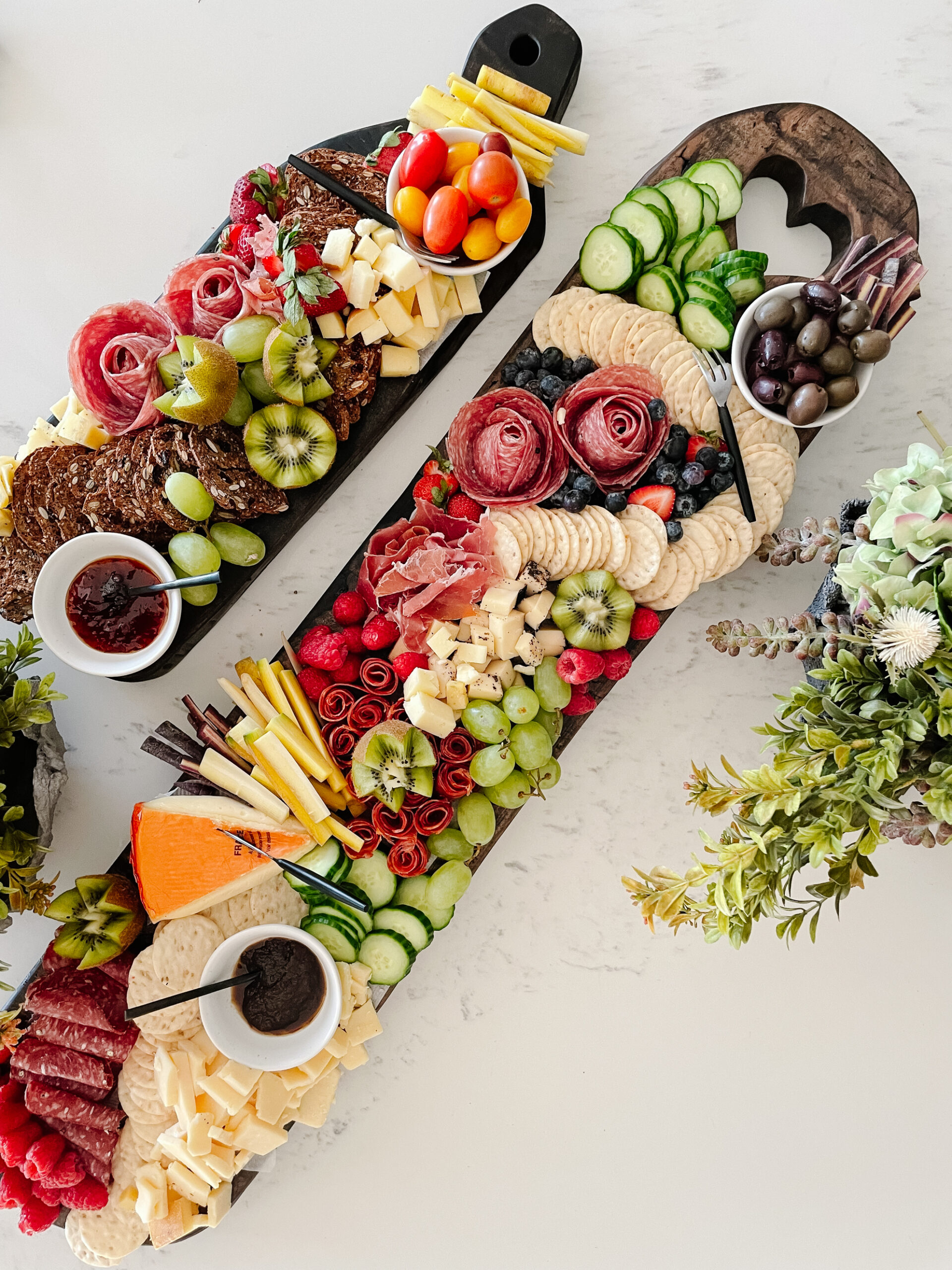 two charcuterie boards on a counter filled with delicious meats and cheeses