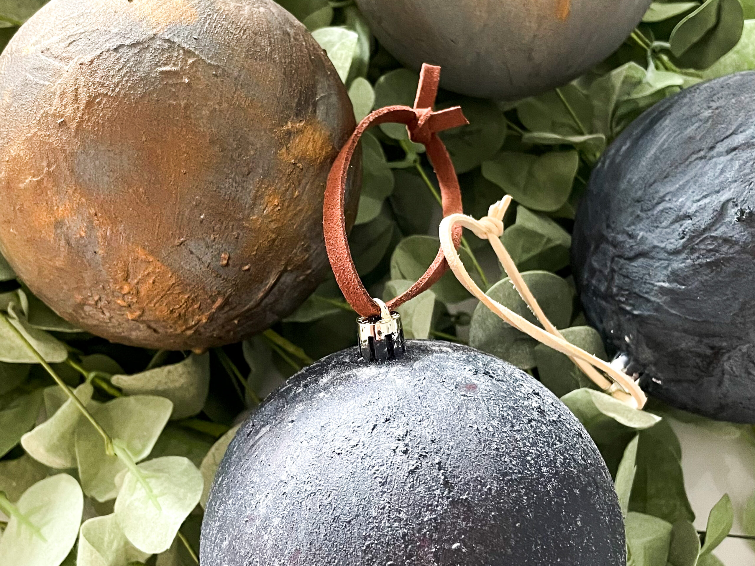 DIY Antiqued Christmas Ornaments on top of eucalyptus