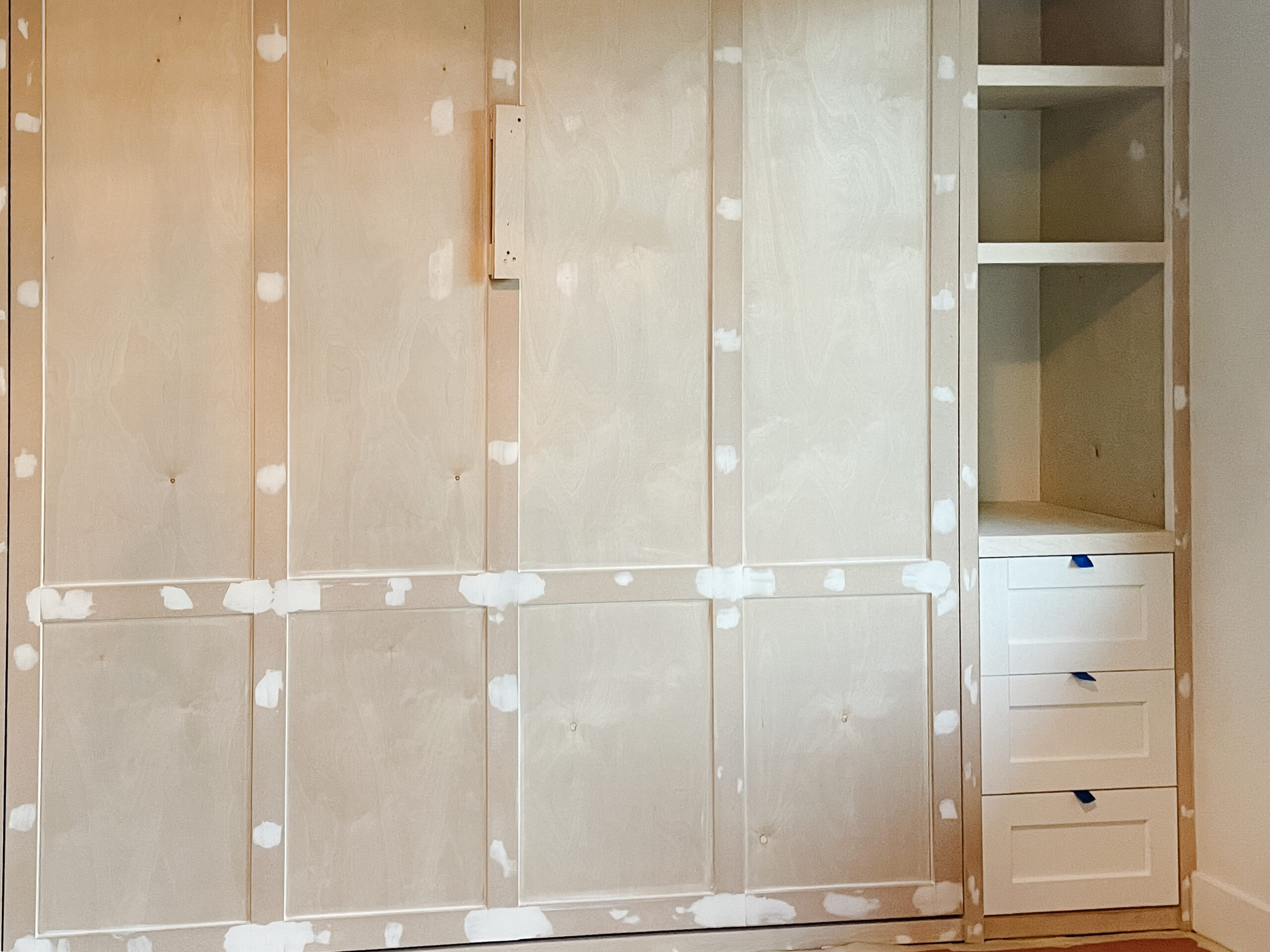 murphy bed built-in is complete with shelves, drawers, cabinets, complete with moulding. yet to be painted.