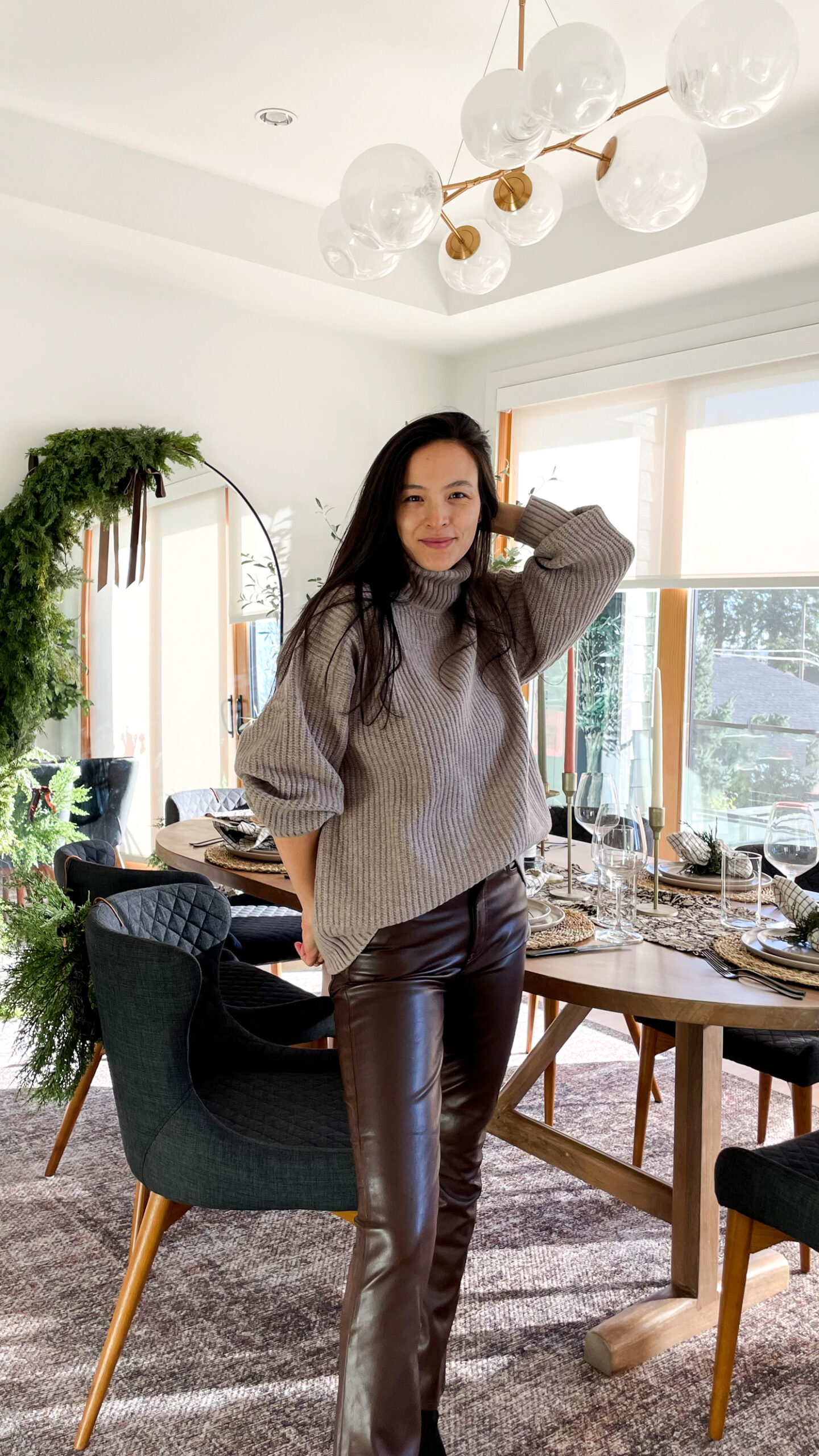 women dressed in holiday outfit setting the table. brown sweater and brown leather pants