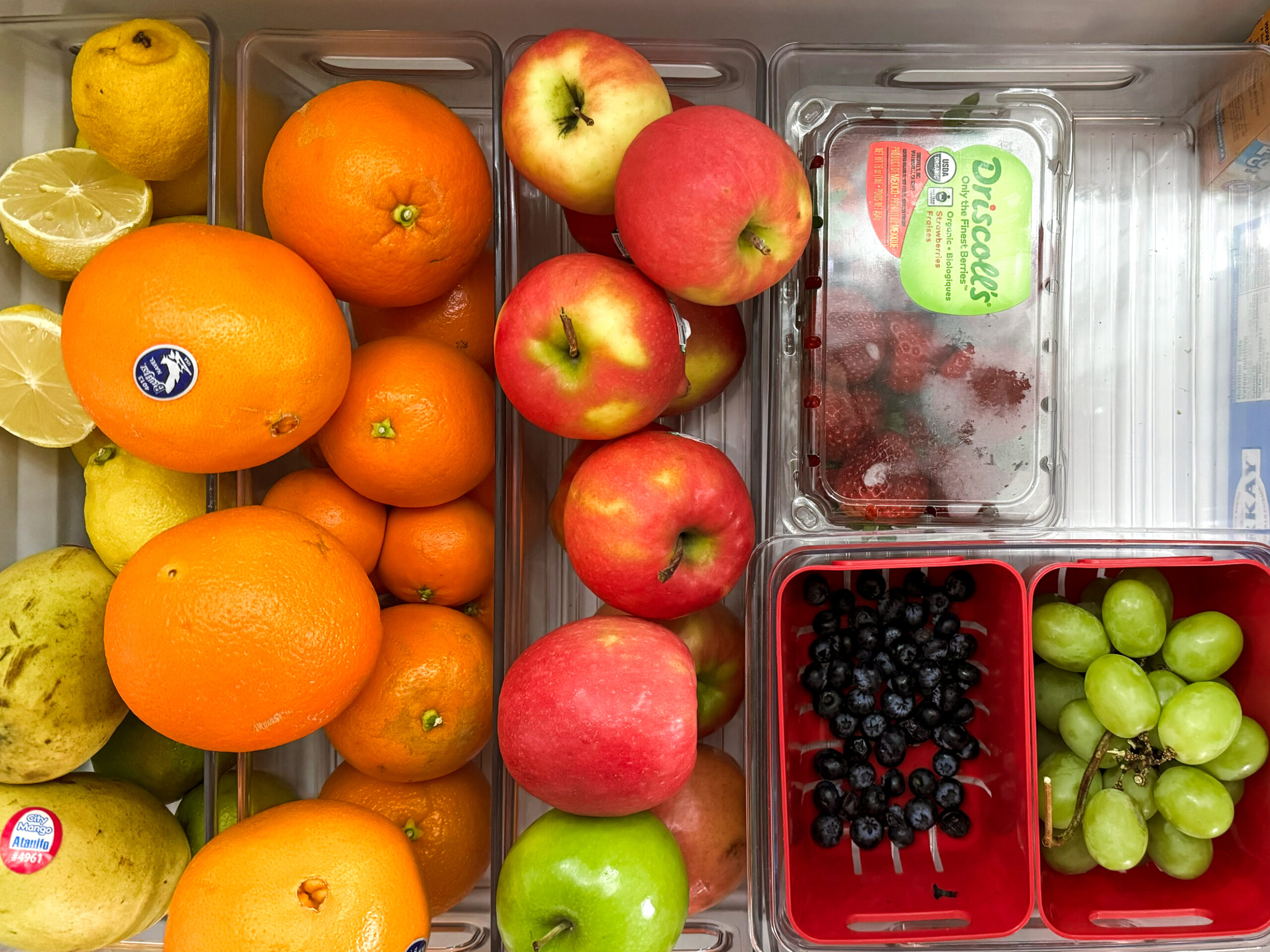 using plastic containers to organize the fruit in your fridge